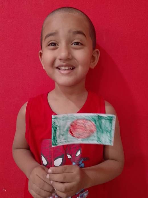 A smiling child holding a hand-coloured flag