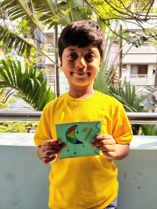 A child holding a handmade Eid card