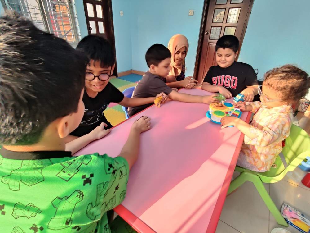Children and a therapist playing together at a table